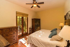 Une chambre à coucher avec un lit, une commode et un ventilateur de plafond.
