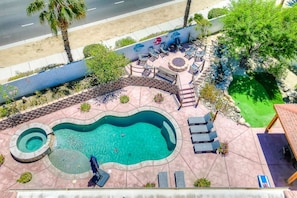 A swimming pool with a circular hot tub, lounge chairs, and a seating area with a fire pit. - Casa Del Sol: #259070 Pool, Spa, Game Room, Court (La Quinta)