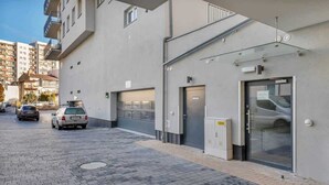 Un edificio moderno con un'area di parcheggio, un basculante e un ingresso in vetro.