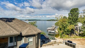 A lakeside property with a house, dock, and boats. - Deck, Hot Tub, Views! Reunion Retreat in Ozarks (Linn Creek)