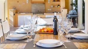 A dining table set for six with plates, wine glasses, and a fruit basket. - Del Pozo by Interhome (Calpe/Calp)