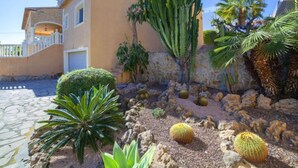 A building with a stone facade, a cactus garden, and a paved entrance. - Del Pozo by Interhome (Calpe/Calp)