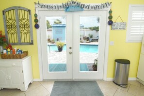 Una puerta con vistas a una piscina y un cartel que dice 'Welcome to Paradise'.