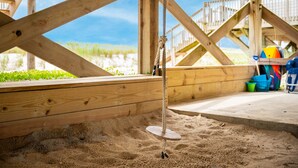 A wooden structure with a swing set and a view of the beach. - Salty But Sweet: Renovated Oceanfront Home on Oak Island with Great Views (Oak Island)