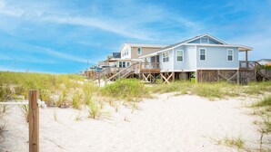 A beachfront property with multiple houses connected by wooden walkways. - Salty But Sweet: Renovated Oceanfront Home on Oak Island with Great Views (Oak Island)