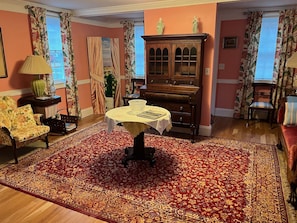Relax in this stylish living room with a large rug, wooden cabinet, and comfortable seating areas.