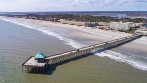 A pier extending into the ocean with a building at the end.
