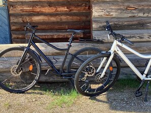 Deux vélos sont garés devant une cabane en rondins de bois.
