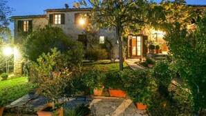 A two-story stone house with a well-maintained garden, outdoor lighting, and a visible door. - Vedi Torre by Interhome (San Gimignano)