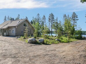 A house with a sloped roof, a porch, and a view of a lake.