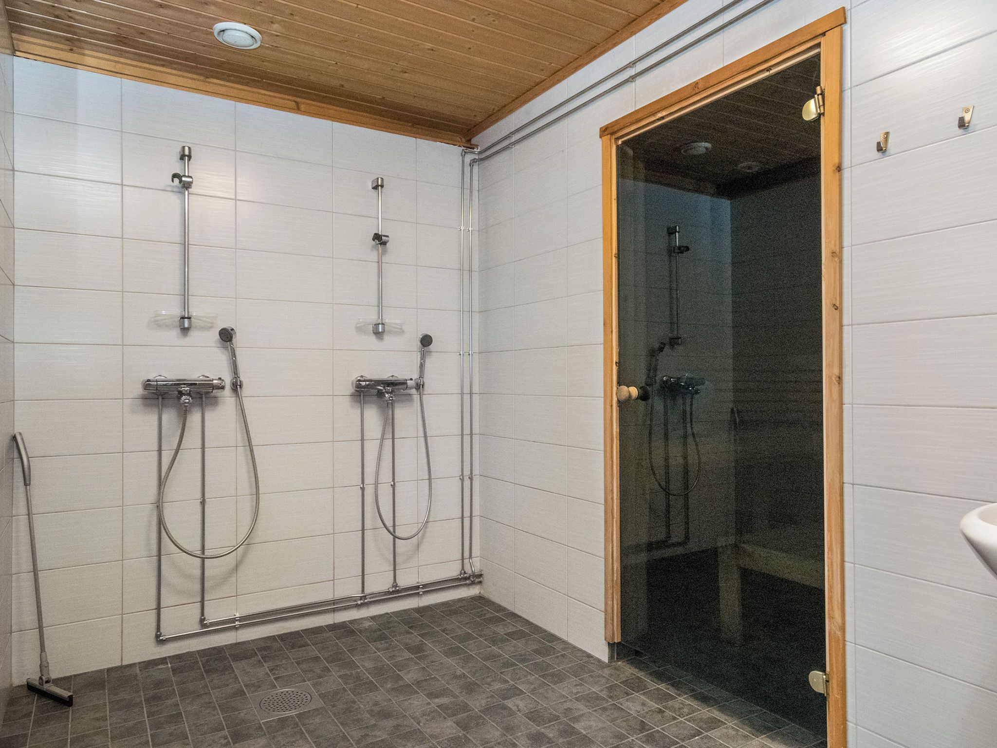 A shower area with multiple showerheads and a glass-enclosed shower stall.