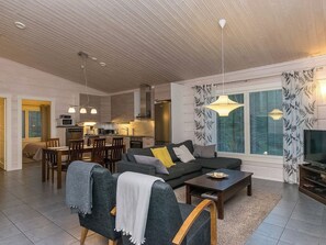A modern living room with a sofa, coffee table, and dining area.