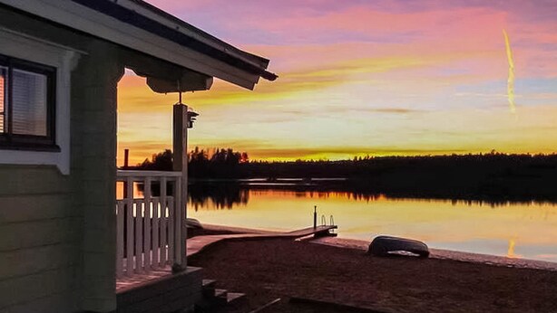A house with a porch overlooking a calm lake at sunset. - Villa mari by Interhome (Pertunmaa)