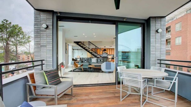 A modern balcony with a dining set, a sofa, and a view into the interior. - Downtown C'ville Luxury w/ Rooftop Terrace (Charlottesville)