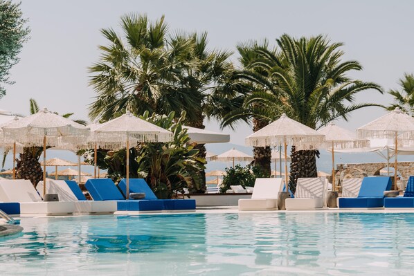 Een buitenzwembad, parasols voor strand/zwembad