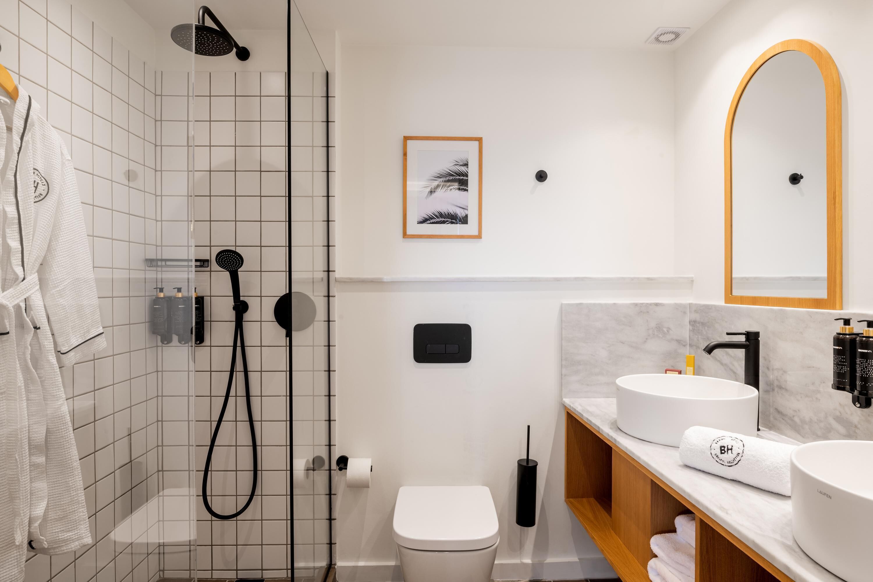 A modern bathroom with a shower, toilet, and vanity with a sink and mirror.