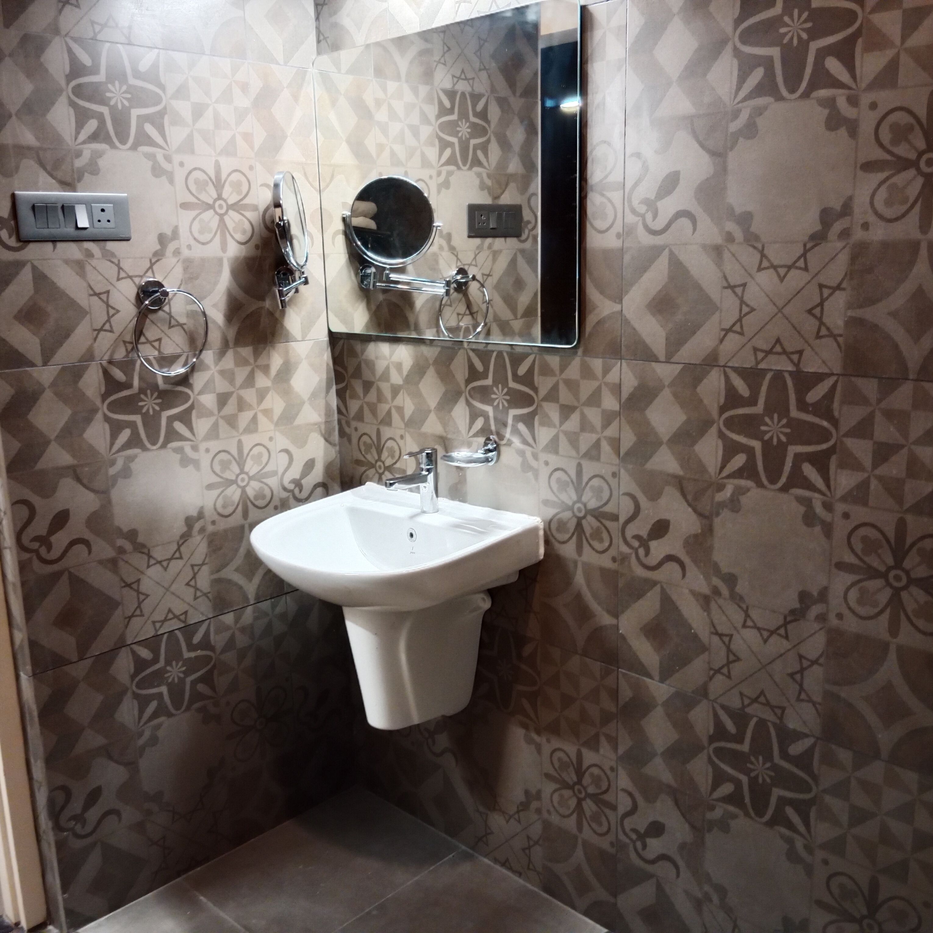A bathroom with a white sink, a mirror, and a towel ring.