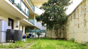 A courtyard with a tiled floor, a tree, and a building with balconies and a fence. - Terrace overlooking the sea and Marche hills (Grottammare)