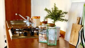 A kitchen counter with a gas stove, a woven basket, and jars with cork stoppers. - Terrace overlooking the sea and Marche hills (Grottammare)