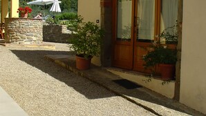Un edificio con fachada de piedra, puerta de madera y plantas en macetas.