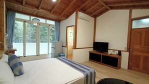A bedroom with a bed, a television on a wooden stand, a window with curtains, and a door. - Tian Pin Guest House (Lugu)