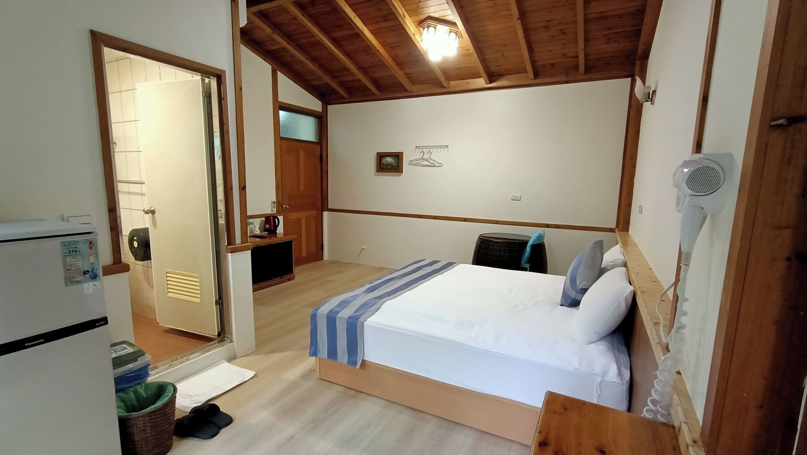 Una camera da letto piccola e accogliente con un letto, un termosifone, uno specchio e una porta che dà su un bagno.