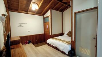 A bedroom with a wooden ceiling, a bed with a white bedspread, a wooden bench, and a coat rack.