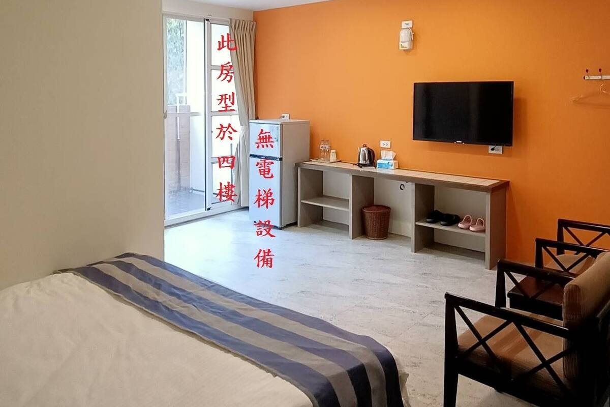 A hotel room with a bed, a desk, a TV, and a chair.