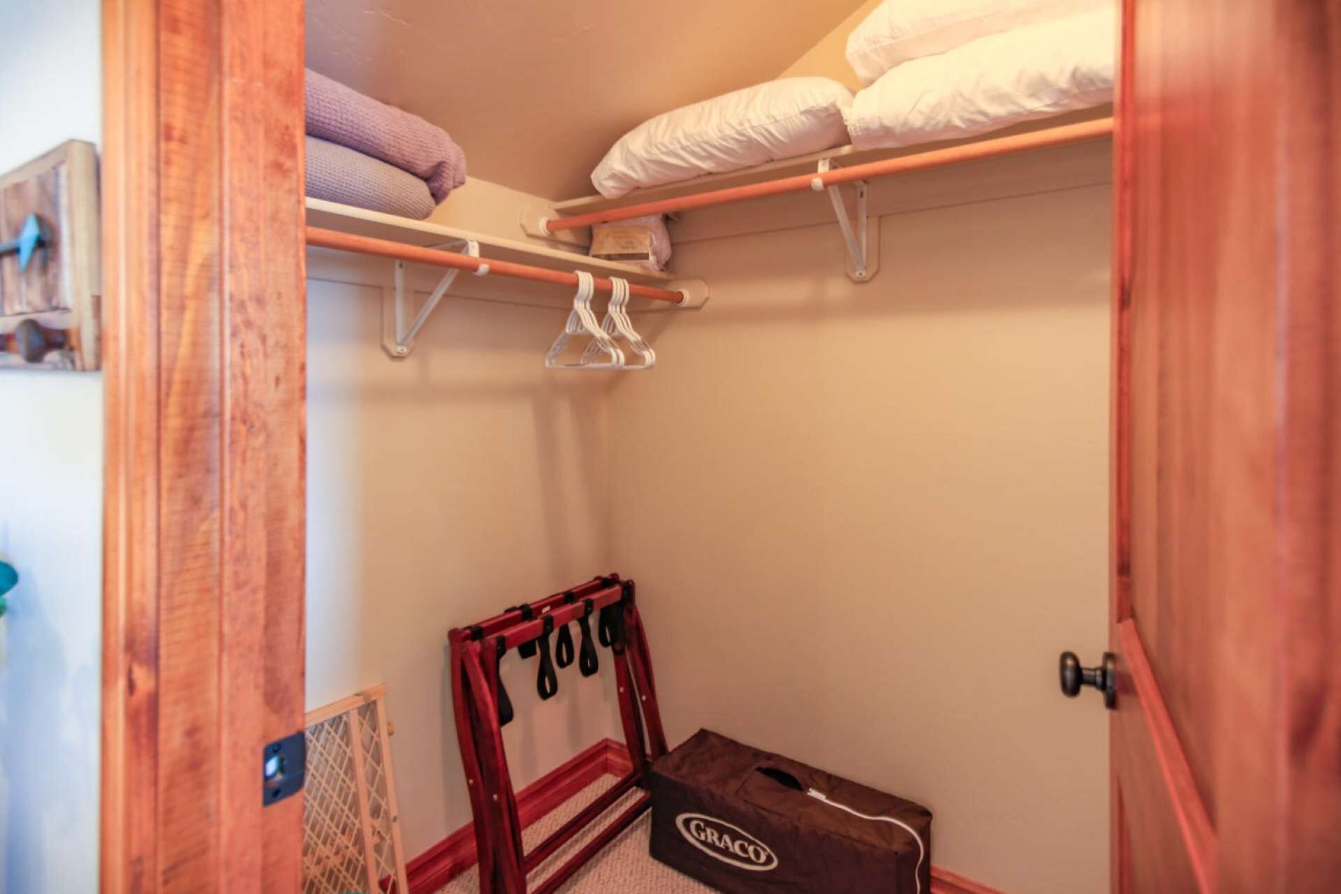 Un armario, una cama, un perchero rojo y un cochecito para bebé Graco.