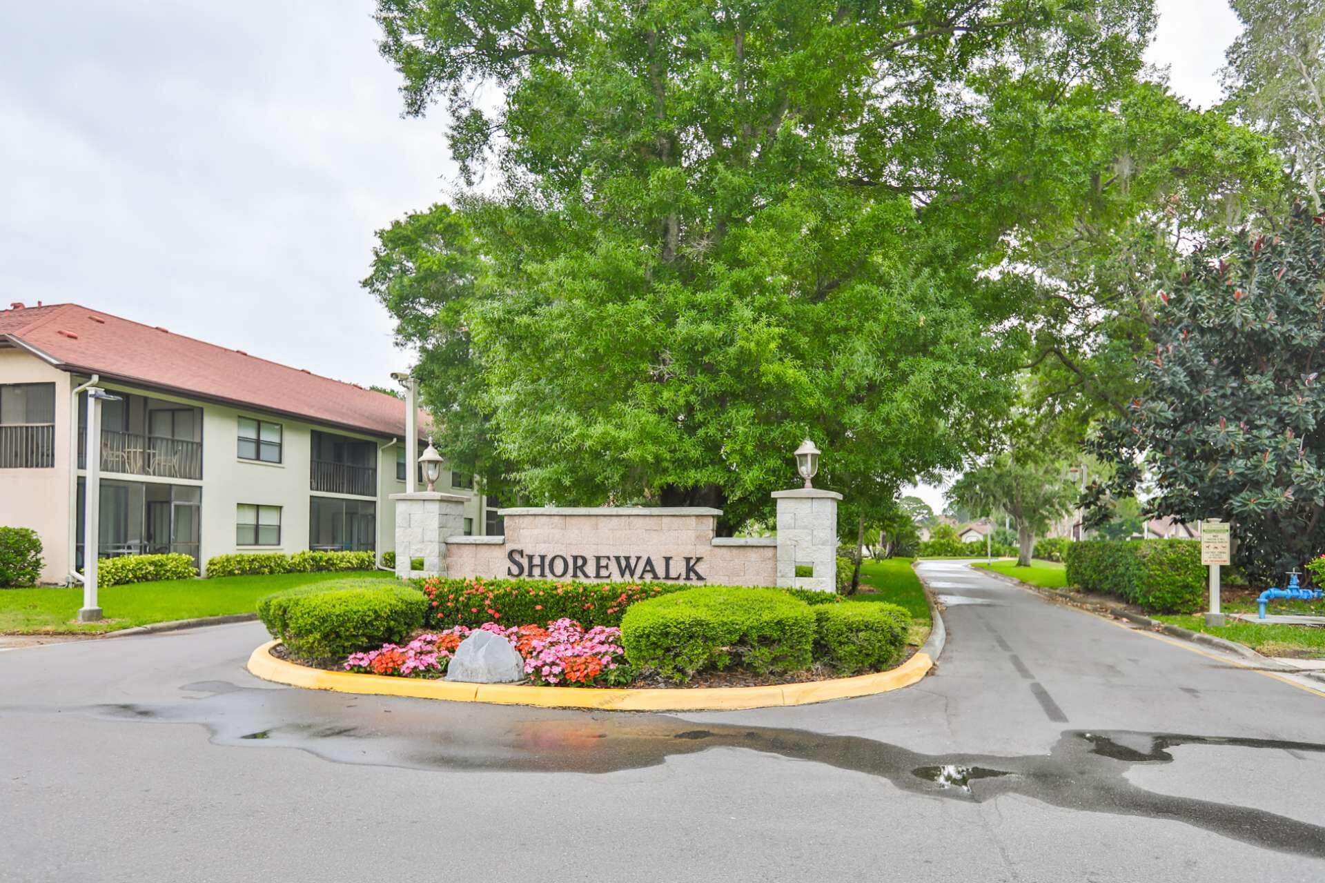 A residential area with a sign reading 'SHOREWALK' and a building with a red roof.