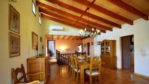 A dining area with wooden furniture, a chandelier, and a tiled floor. - 44380 Finca Pula Viñas (Son Servera)