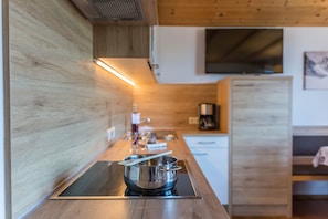 A modern kitchen with a wooden countertop, stainless steel cookware, and a built-in stove.