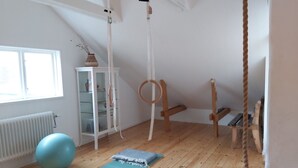 A room with a wooden floor, a blue exercise mat, a white cabinet with glass doors, a wooden swing, and a rope swing. - 140 sqm and garden in cozy and city near Kålltorp, also Gothia cup (Kålltorp)