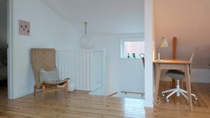 A room with a wooden floor, a wooden chair with a patterned cushion, a desk with a chair, a window with blinds, and a ceiling light fixture. - 140 sqm and garden in cozy and city near Kålltorp, also Gothia cup (Kålltorp)