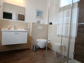 Un baño moderno con ducha, inodoro y lavamanos.
