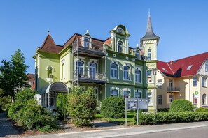 A row of colorful historic buildings with distinct architectural styles, including a tower with a spire.