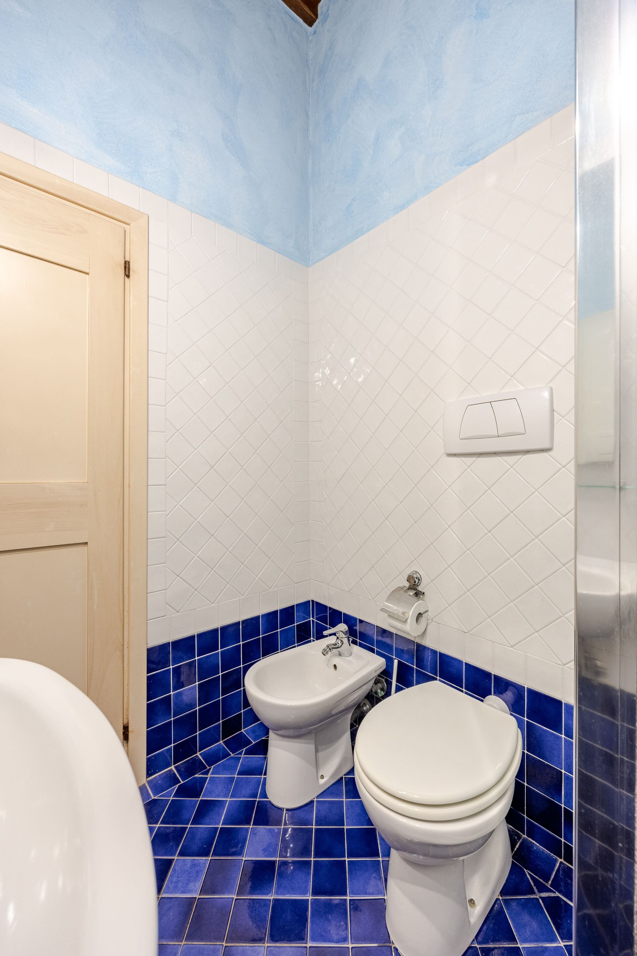 Une salle de bain équipée de toilettes, d’un bidet et d’un lavabo.