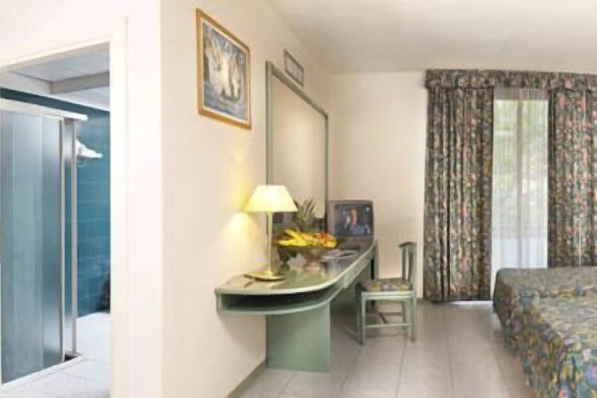 Driepersoonskamer | Een minibar, een kluis op de kamer, een bureau, verduisterende gordijnen