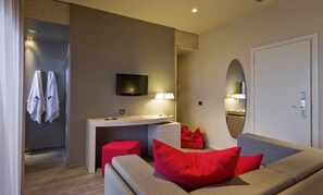 Suite junior, vista al mar | Área de sala de estar | Televisión