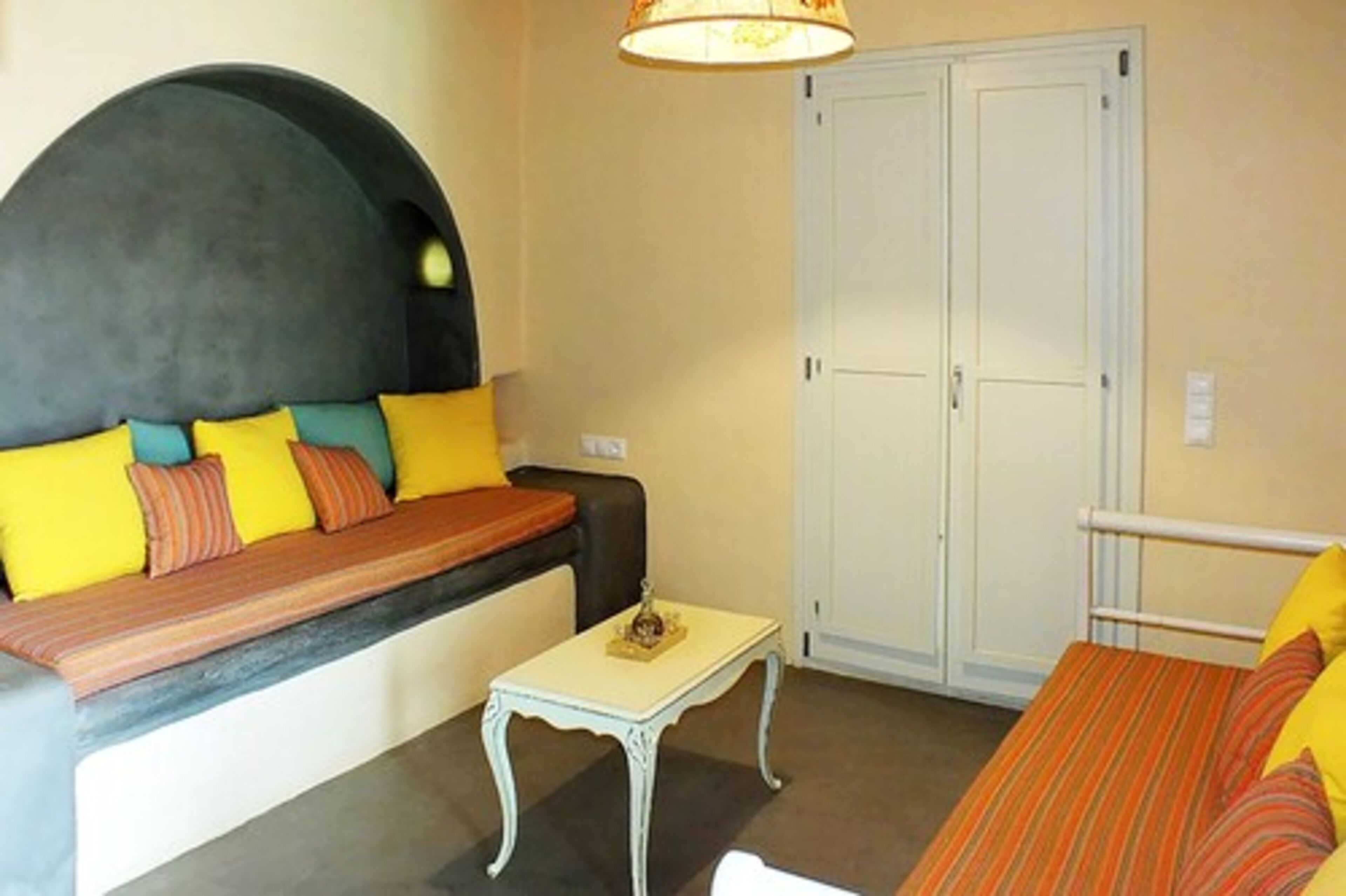 A compact room with a sofa bed, a small table, and a wardrobe.