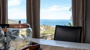 A table with a view of the sea, a wooden chair, and a glass jar with flowers. - Ground floor of beautiful villa T2 - 70 m2 - 4 people with magnificent sea views (Bastia)