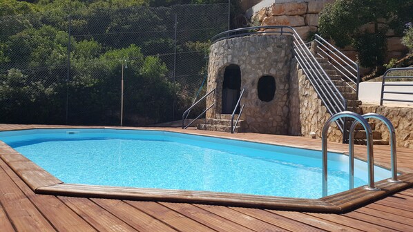 A swimming pool with a wooden deck, stone steps, and metal railings. - Janelas da Baía - By SCH (São Martinho do Porto)