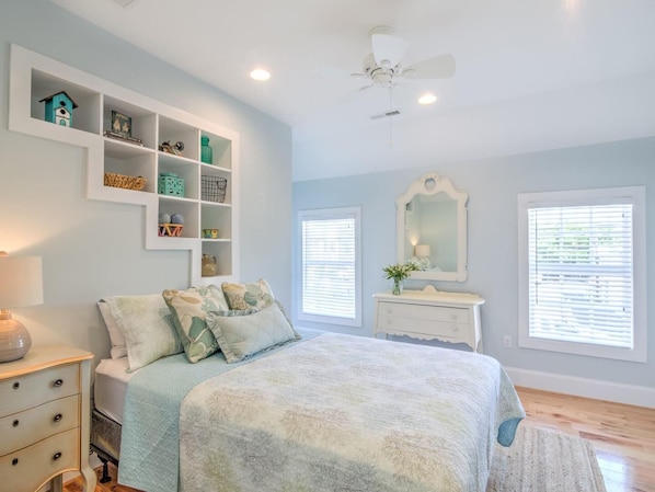 A bedroom with a bed, a dresser, a vanity, a ceiling fan, and built-in shelves with various items. - Downtown St. Michaels | Walk to Shops, Restaurants and Nightlife (St. Michaels)