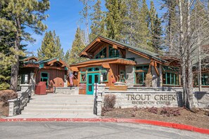 Eine Lodge mit Steineingang, Holzfassade und einem Schild mit der Aufschrift 'Trout Creek Recreation Center'.