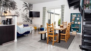 Una sala de estar moderna con comedor, cocina y escalera.
