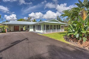 A single-story house with a covered porch, a garage, and a well-maintained lawn. - Hale O Nani Mala Pua 3 Bedroom Home by RedAwning (Pahoa)