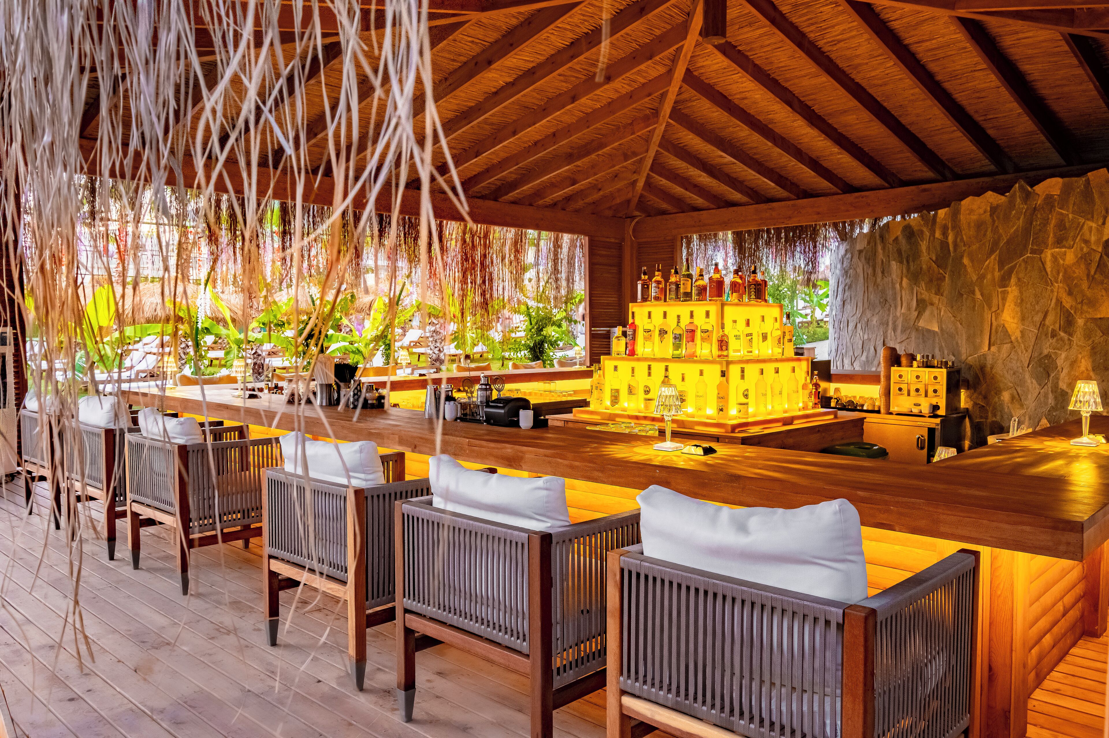 A bar area with wooden furniture and a stone wall.
