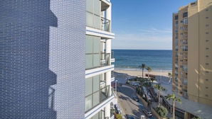 Un edificio a più piani con balconi affacciati su una spiaggia e l'oceano.