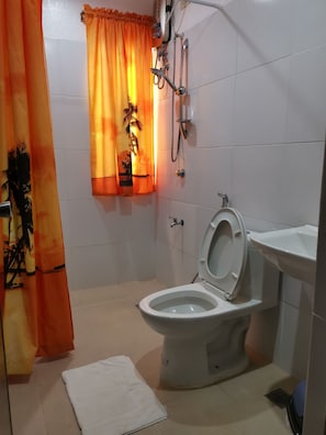 A bathroom with a toilet, a shower, and a sink. - Mt. Bagarabon Beach and Mountain Resort (Surigao)