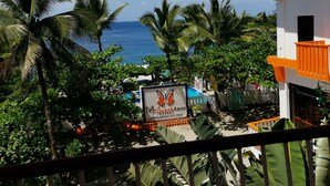 Vue d’une propriété située en bord de mer, avec une enseigne indiquant « Maya Beach Resort & Spa » et une zone avec piscine.